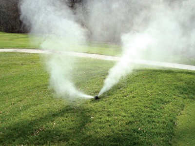 Technician blowing out an irrigation/sprinkler system for winterization